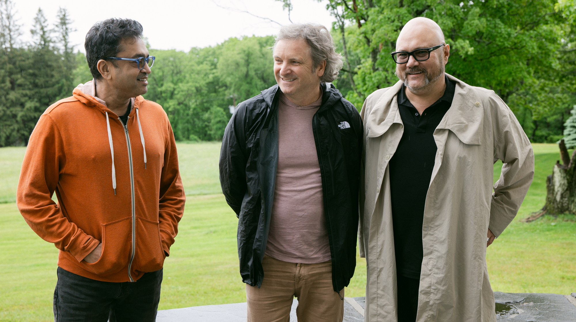 Three people smiling outdoors.