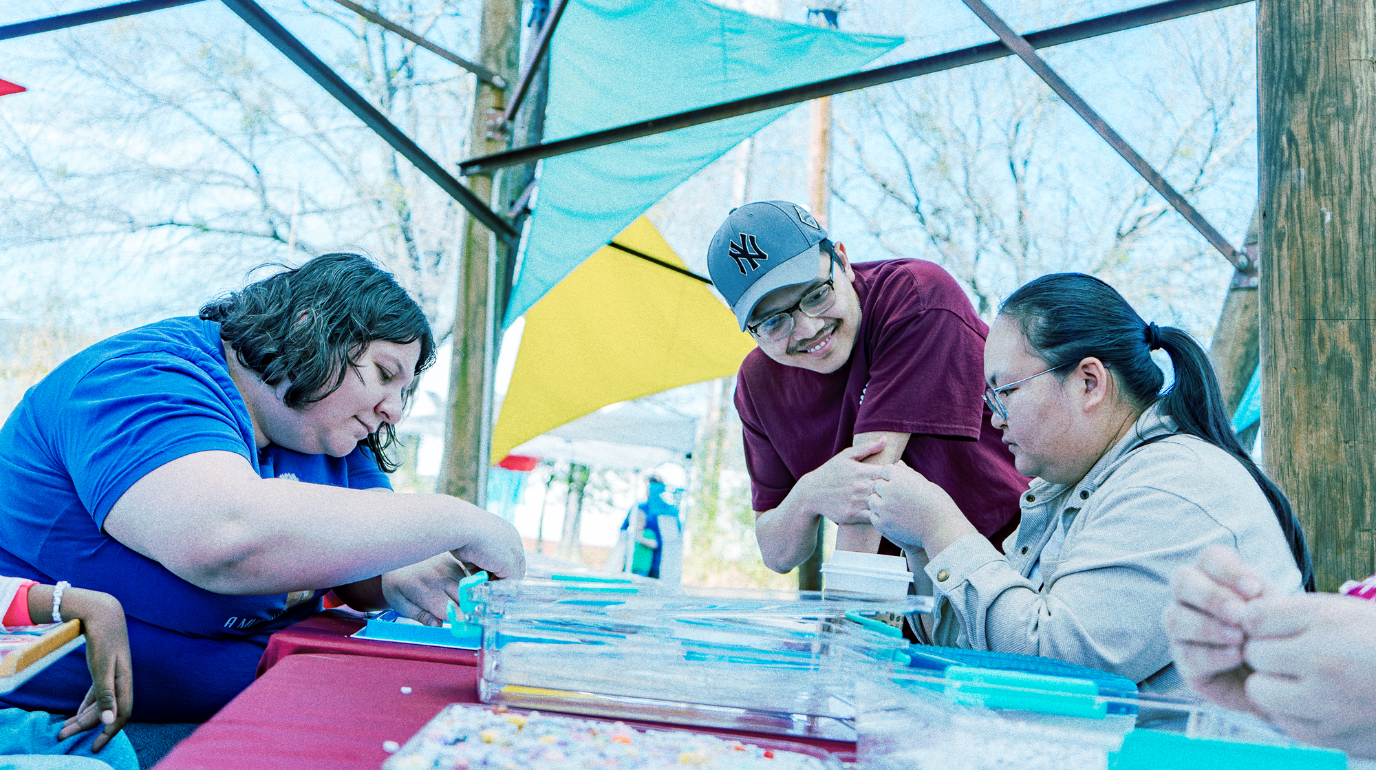Photo of people working on crafts at a table.